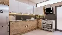 Cuisine en L – En teck, avec un plan de travail en granit.