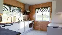 Cuisine en L – Finition blanche mate, avec un plan de travail en granit.