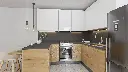 Cuisine en U – En teck, avec un plan de travail en granit.