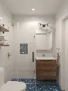 Salle de bain moderne avec sol bleu géométrique et finitions dorées