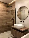 Salle de bain moderne avec douche en carrelage effet bois et accents noirs