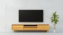 Meuble TV minimaliste en bois clair sur fond en béton